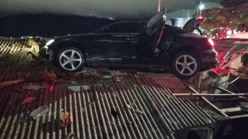 Carro cai em cima de casa e fica pendurado em telhado no Sul de Minas